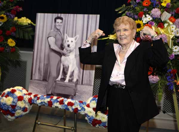Elaine LaLannne strikes a characteristic pose near a portrait of her late husband Jack LaLanne at a memorial service for guru of physical fitness in Los Angeles Tuesday, Feb. 1, 2011. LaLanne died Jan. 23 at the age of 96. (AP Photo/Reed Saxon)
